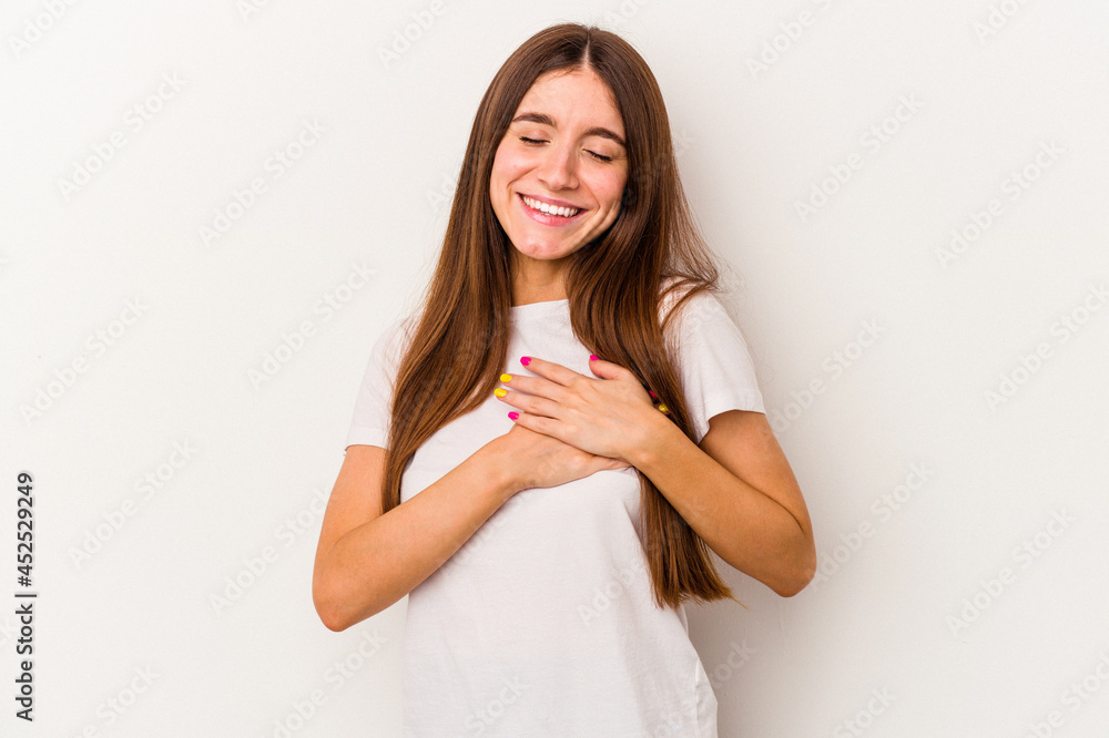 Young caucasian woman isolated on white background has friendly expression, pressing palm to chest. Love concept. Young caucasian woman isolated on white background has friendly expression, pressing palm to chest. Love concept.