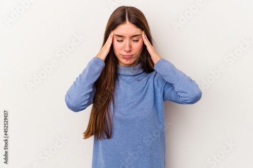 Young caucasian woman isolated on white background having a head ache, touching front of the face. © Asier