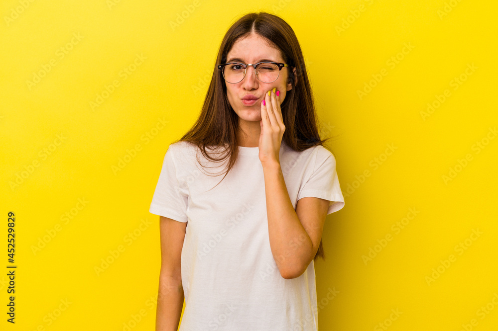 Young caucasian woman isolated on yellow background having a strong teeth pain, molar ache. Young caucasian woman isolated on yellow background having a strong teeth pain, molar ache.