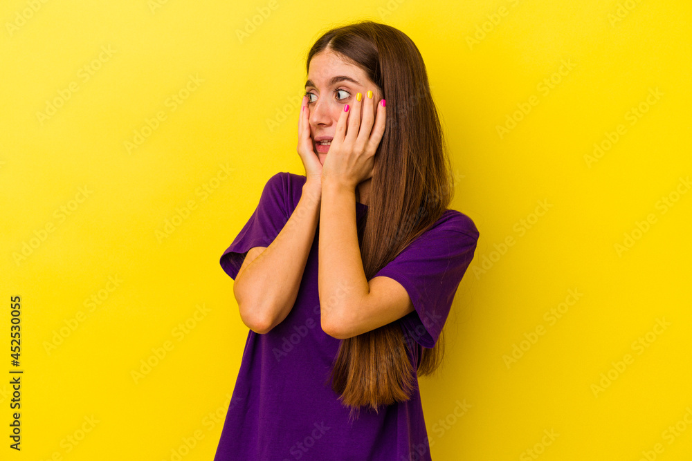 Young caucasian woman isolated on yellow background scared and afraid. Young caucasian woman isolated on yellow background scared and afraid.