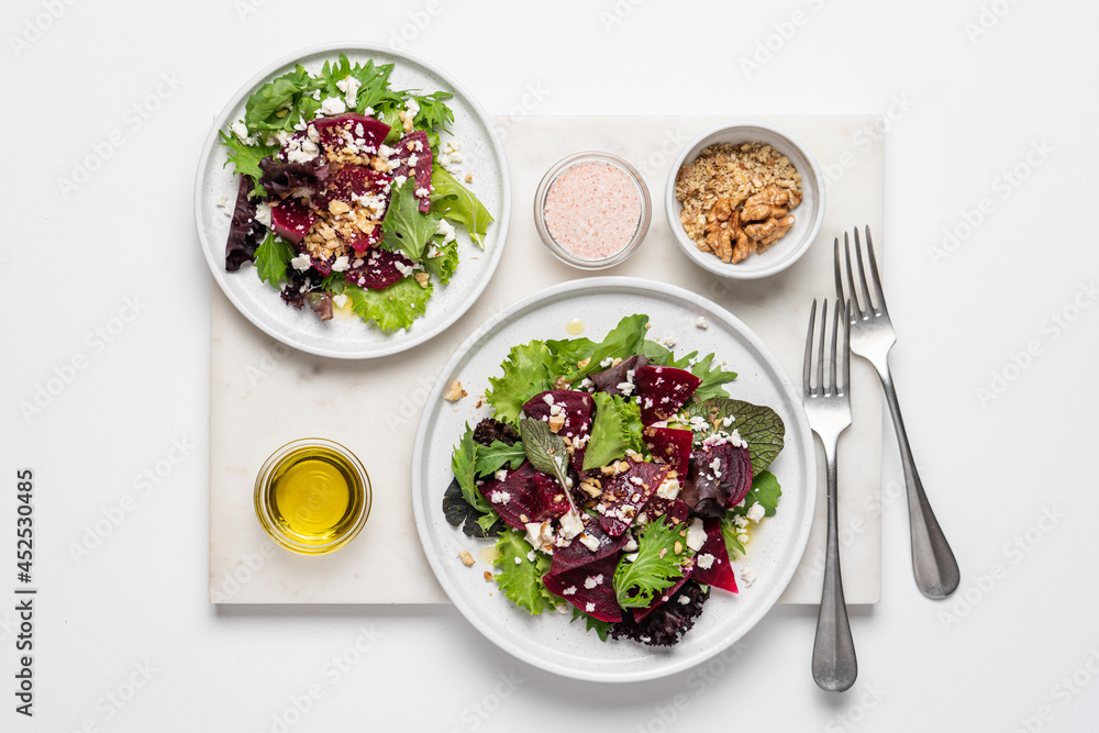 Beetroot salad with feta cheese and walnuts. Vegetable salad in plate on white background, top view Beetroot salad with feta cheese and walnuts. Vegetable salad in plate on white background, top view