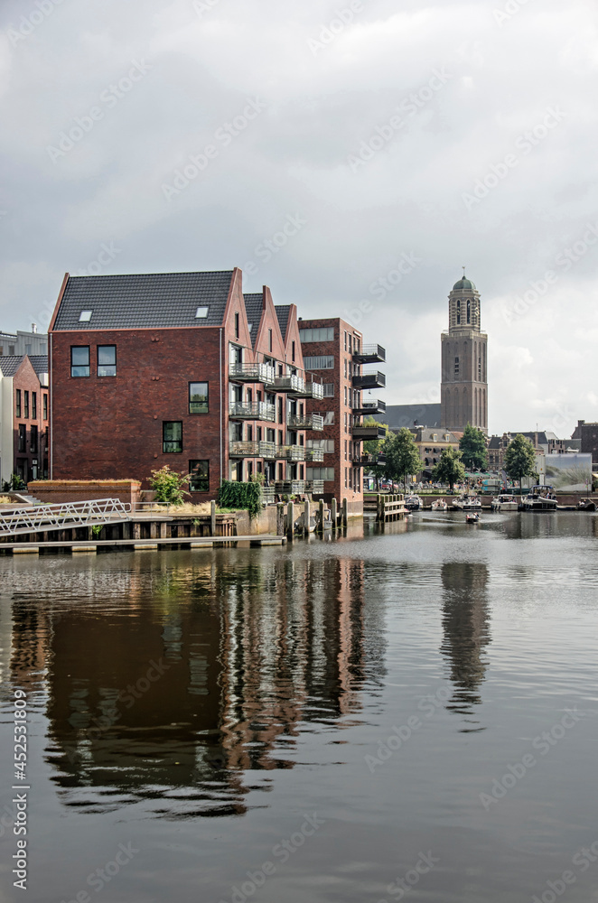 Obraz premium Zwolle, The Netherlands, August 20, 2021: recently built houses in the Kraanbolwerk area, togeter with the iconic Peperbus church tower