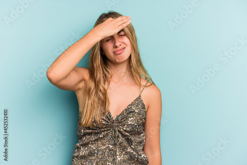 Young caucasian blonde woman isolated on blue background  touching temples and having headache.