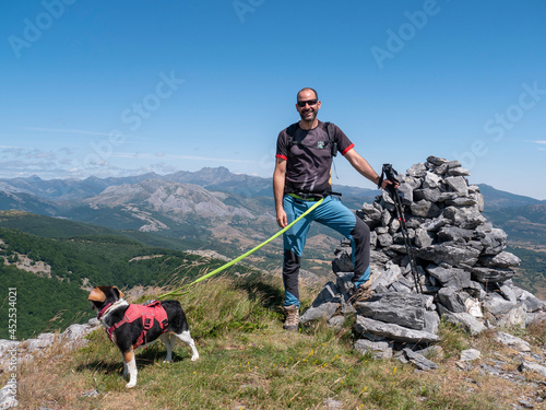Closeup of a Caucasian man on top of the mountain in Spain hiking in the mountains with his dog