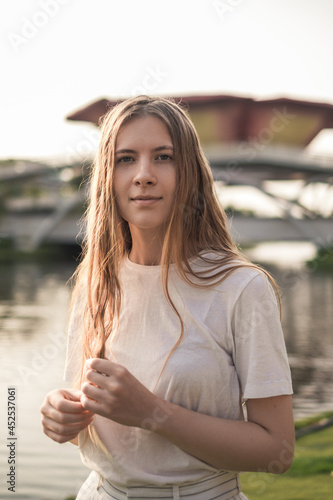 Close-up portrait of beautiful caucasian woman with blond hair walking outdoors. Attractive Girl without Makeup in White t-shirt. Natural Skin Beauty.