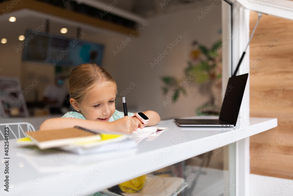 happy caucasian kid has online lesson on laptop during coronavirus covid-19 pandemic and lockdown happy caucasian kid has online lesson on laptop during coronavirus covid-19 pandemic and lockdown