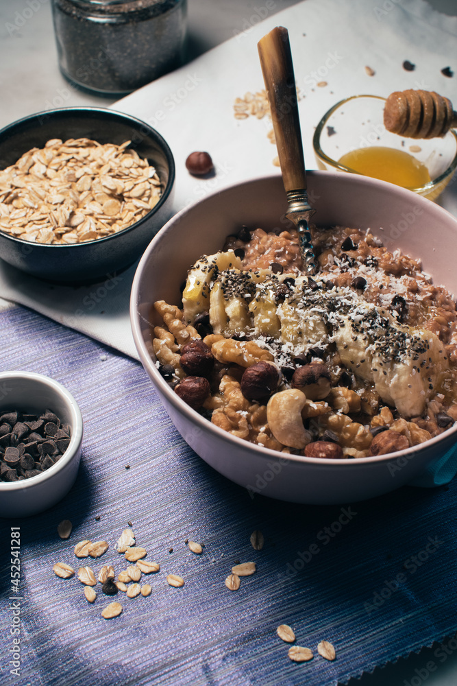 Bowl of oatmeal porridge with banana and nuts. Top view. Healthy vegan breakfast