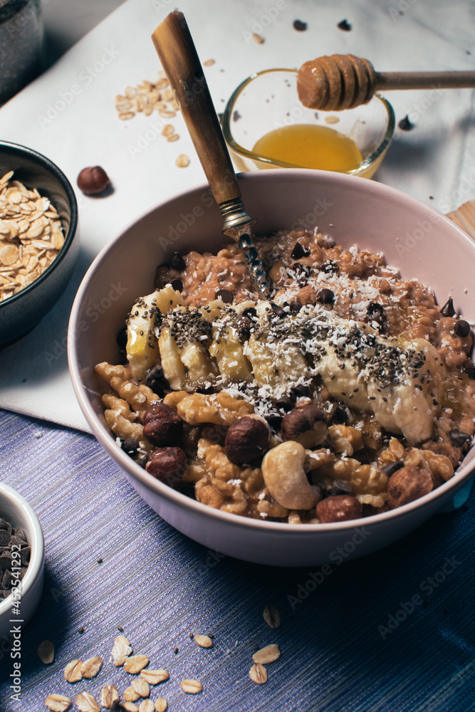 Bowl of oatmeal porridge with banana and nuts. Top view. Healthy vegan breakfast