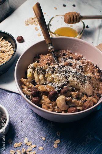 Obraz na płótnie Bowl of oatmeal porridge with banana and nuts. Top view. Healthy vegan breakfast w salonie