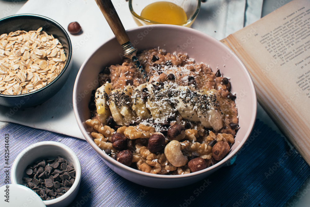 Bowl of oatmeal porridge with banana and nuts. Top view. Healthy vegan breakfast