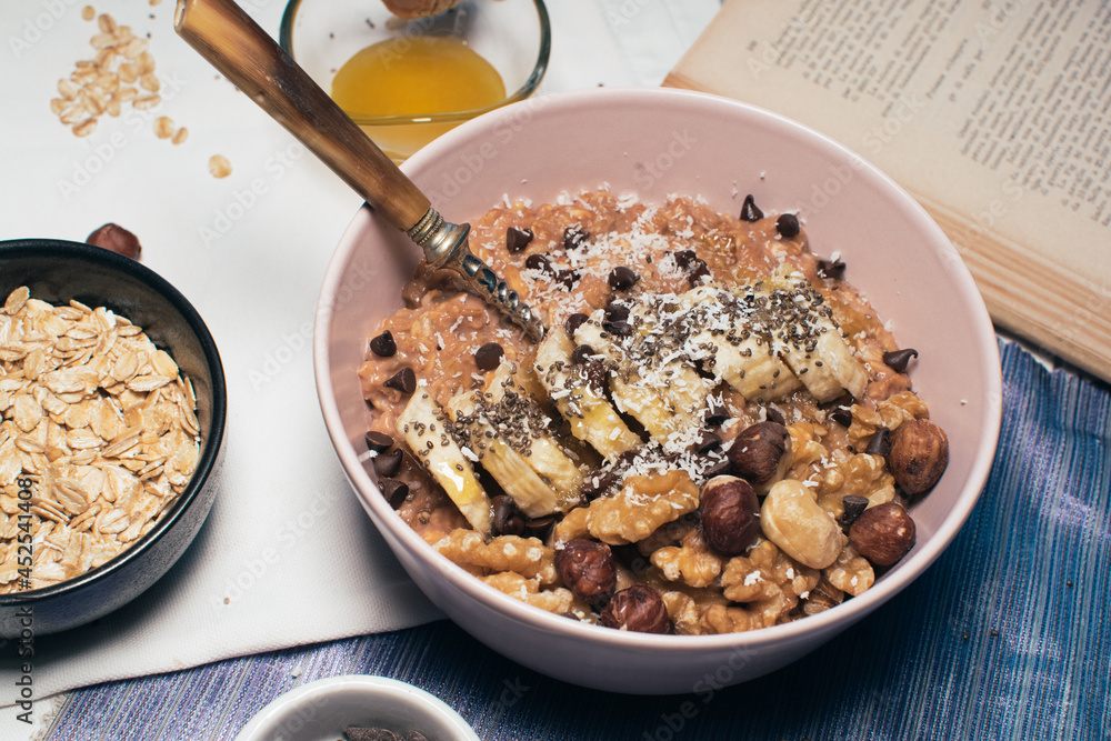 Bowl of oatmeal porridge with banana and nuts. Top view. Healthy vegan breakfast