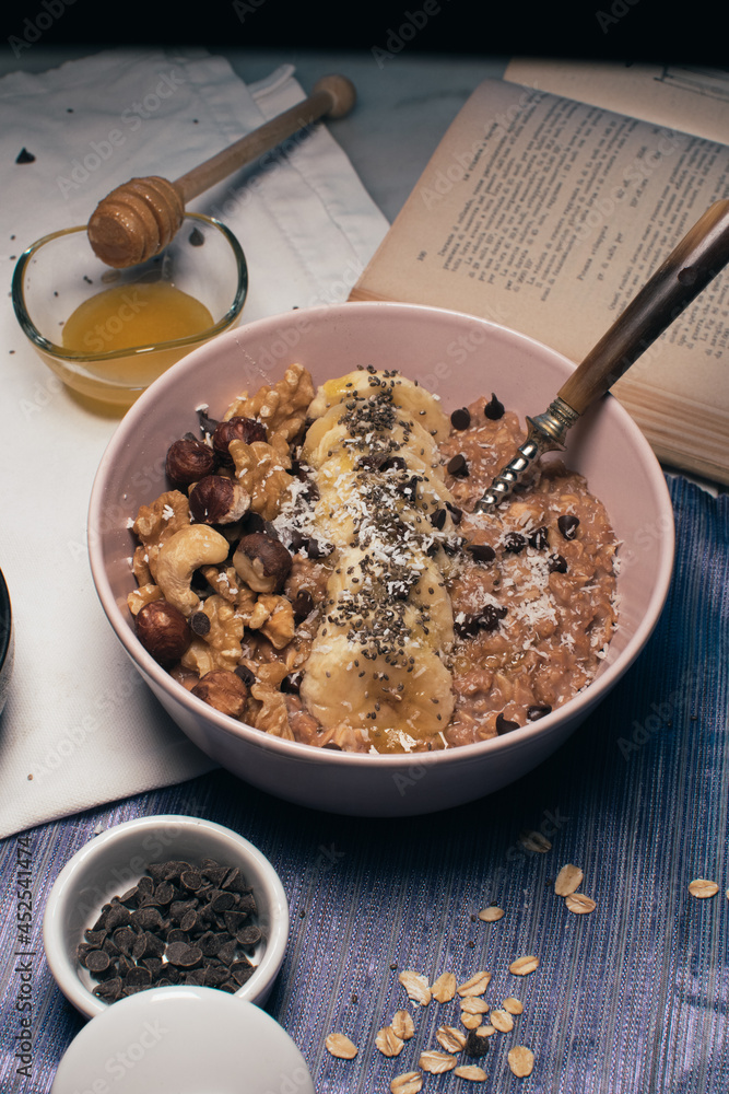 Bowl of oatmeal porridge with banana and nuts. Top view. Healthy vegan breakfast