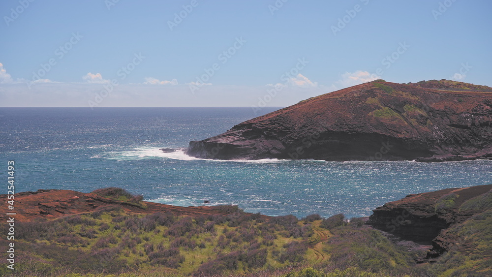 Amazing view of Hanauma Bay Oahu Hawaii. The turquoise waves of the Pacific Ocean wash over volcanic rocks. Summer vacations in Hawaii.