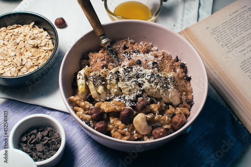 Obraz na płótnie Bowl of oatmeal porridge with banana and nuts. Top view. Healthy vegan breakfast w salonie