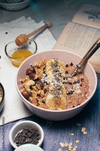 Obraz na płótnie Bowl of oatmeal porridge with banana and nuts. Top view. Healthy vegan breakfast w salonie