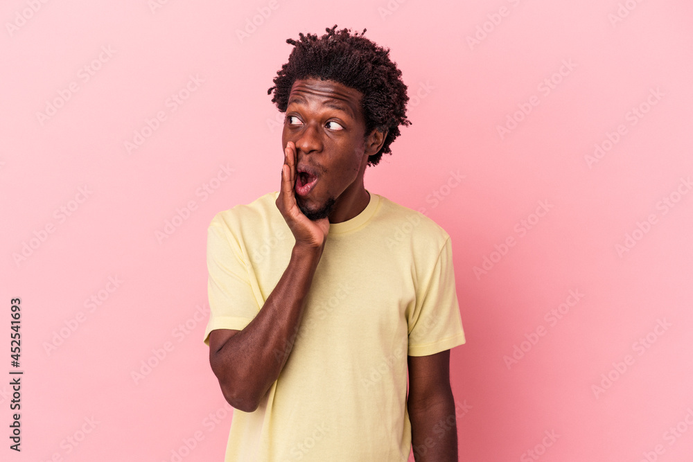 Young african american man isolated on pink background is saying a secret hot braking news and looking aside Young african american man isolated on pink background is saying a secret hot braking news and looking aside