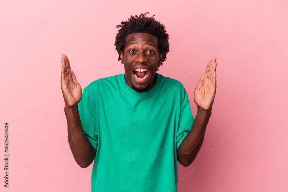 Young african american man isolated on pink background receiving a pleasant surprise, excited and raising hands. Young african american man isolated on pink background receiving a pleasant surprise, excited and raising hands.