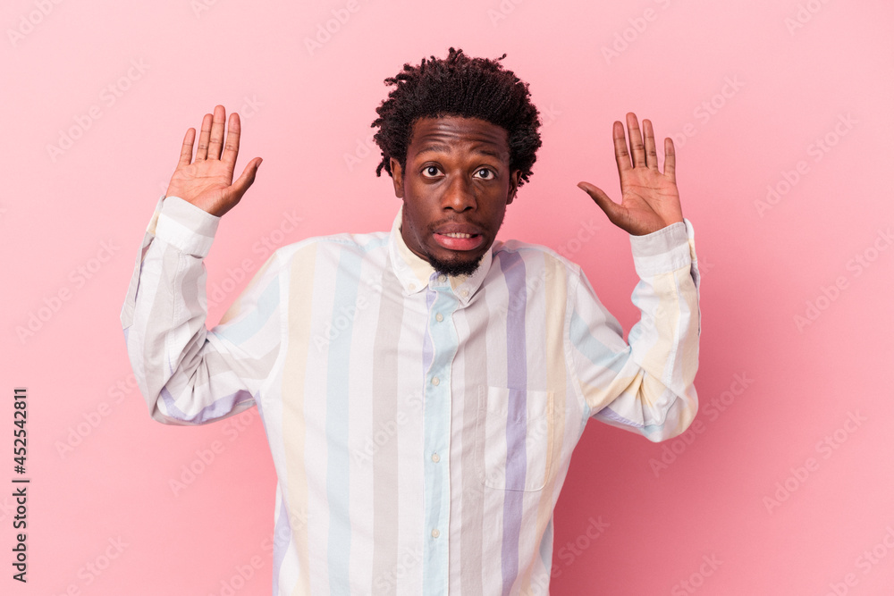 Young african american man isolated on pink background being shocked due to an imminent danger Young african american man isolated on pink background being shocked due to an imminent danger