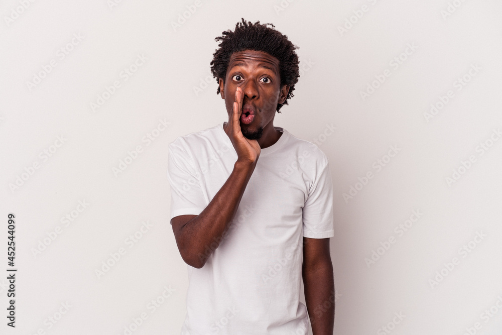 Young african american man isolated on white background is saying a secret hot braking news and looking aside Young african american man isolated on white background is saying a secret hot braking news and looking aside