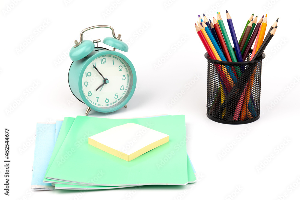 School items. Alarm clock, notebooks, pencils for drawing on a white background. Concept of education, back to school, creativity and learning. Copy space. School items. Alarm clock, notebooks, pencils for drawing on a white background. Concept of education, back to school, creativity and learning. Copy space.