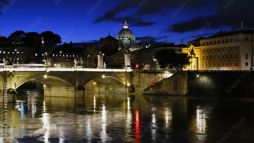 Sant' Angelo Bridge And Basilica Of St. Peter At Night In Rome, Italy