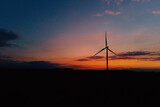 Windmill silhouette at sunset sky. Wind turbine generator. Wind energy concept. Suistanable and renewable energy for climate protection