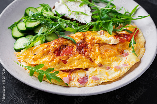 Breakfast. Omelette with tomatoes, cheese and salad on white plate. Frittata - italian omelet.