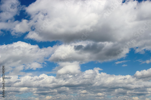 cumulus clouds float in the sky on a clear summer day