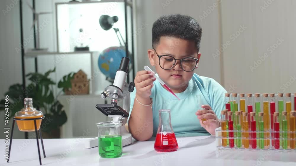 Little Boy Mixes Chemicals In Test Tube. Child Learn With Interest
Little Boy Mixes Chemicals In Test Tube. Child Learn With Interest