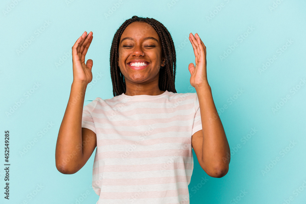 Young african american woman isolated on blue background joyful laughing a lot. Happiness concept. Young african american woman isolated on blue background joyful laughing a lot. Happiness concept.