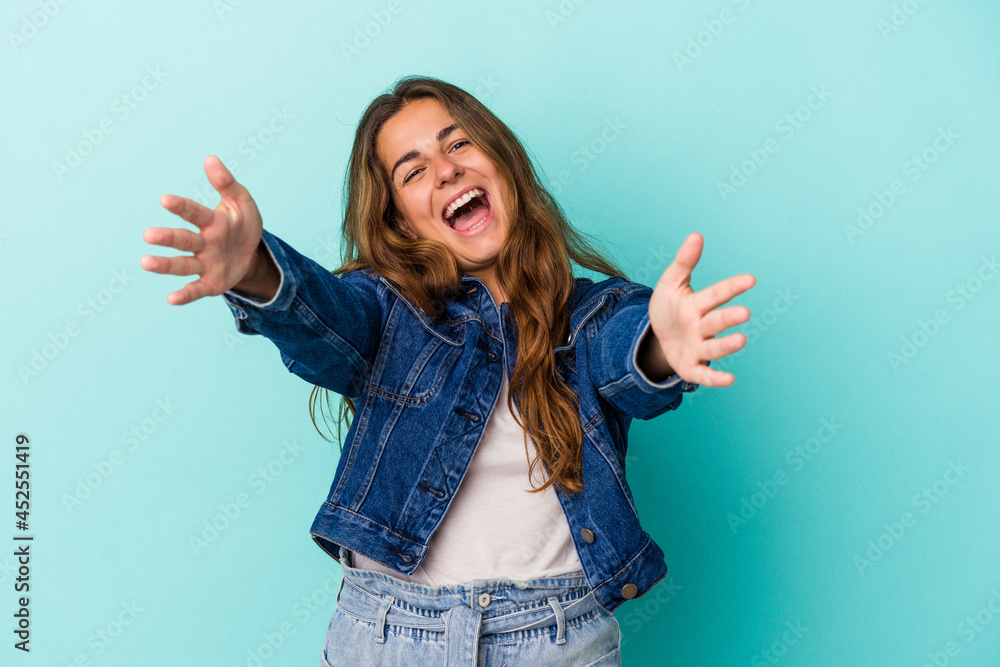 Young caucasian woman isolated on blue background feels confident giving a hug to the camera. Young caucasian woman isolated on blue background feels confident giving a hug to the camera.