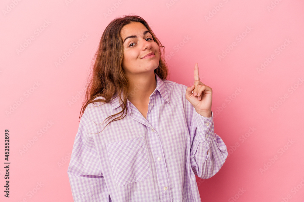 Young caucasian woman isolated on pink background showing number one with finger. Young caucasian woman isolated on pink background showing number one with finger.