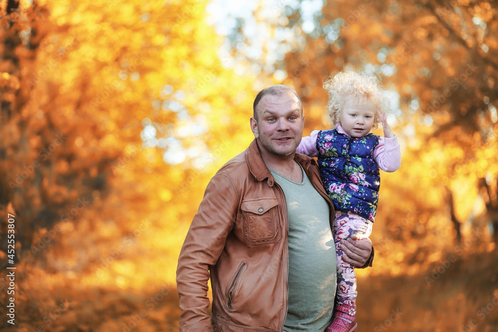 Girl walking in the autumn park. Autumn in the city, girl with dad for a walk. Parents are walking with little children. Autumn park people Girl walking in the autumn park. Autumn in the city, girl with dad for a walk. Parents are walking with little children. Autumn park people