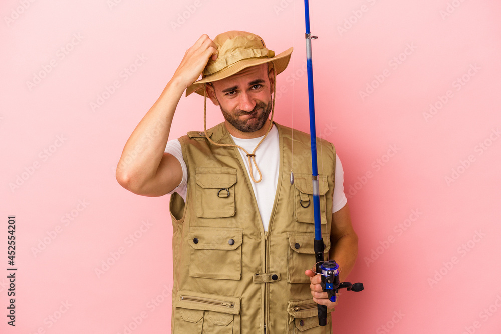 Young bald fisherman holding a rod isolated on pink background being shocked, she has remembered important meeting. Young bald fisherman holding a rod isolated on pink background being shocked, she has remembered important meeting.