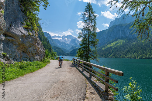 Gosausee, Austria  July 31, 2021 - A person on a mountainbike at Gosausee, a beautiful lake with moutains in Salzkammergut, Austria. © Nick Brundle