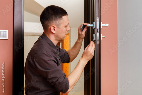 Handyman in blue uniform works with electricity automatic screwdriver. House renovation conception.