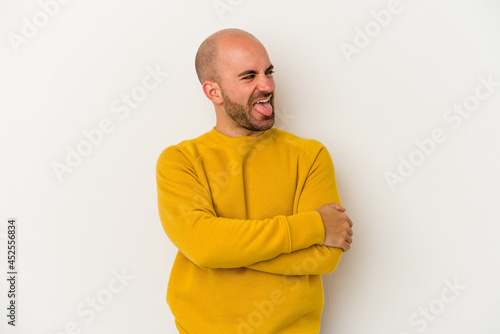 Young bald man isolated on white background funny and friendly sticking out tongue.