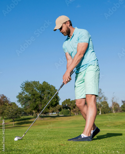 golfer in cap with golf club. people lifestyle. man playing game on green grass. summer activity