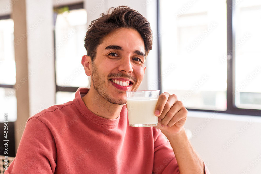 Young mixed race man drinking milk for breakfast Young mixed race man drinking milk for breakfast