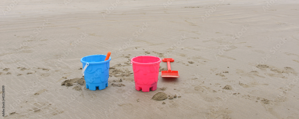 Panoramique jouets d'enfants seaux bleu et rose abandonnés sur la plage Panoramique jouets d'enfants seaux bleu et rose abandonnés sur la plage