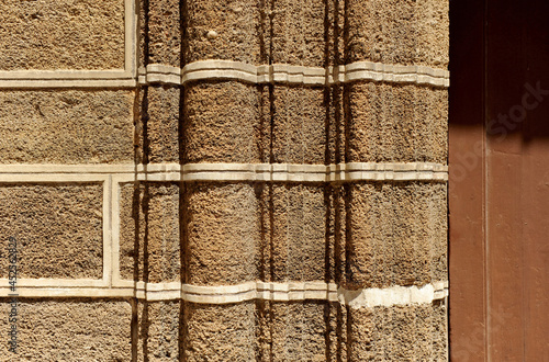 Piedra ostionera material de construcción muy utilizado en la arquitectuta de Cádiz y pueblos de alredededor. Molduras de sillares de piedra ostionera en la puerta de entrada de una casa importante. photo