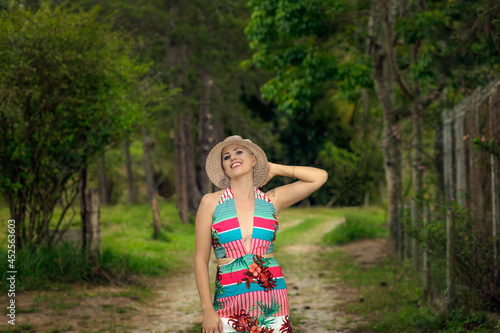 Beautiful and strong woman fighting breast cancer Smiling and happy. In hat on the road and street in the forest. Hairless and bald. live and joy of fighting. Dancing Sexy Dress of flowers in nature.