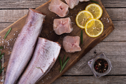 Raw hake on wooden background