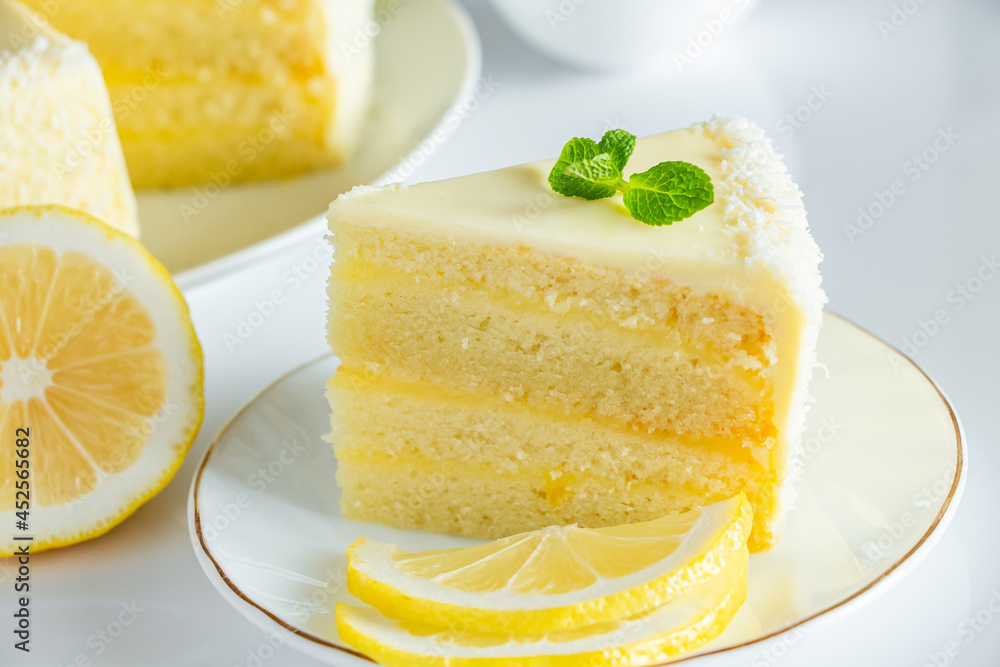 Piece of biscuit dessert with lemon and coconut flakes. Layered vanilla cake on white plate. Piece of biscuit dessert with lemon and coconut flakes. Layered vanilla cake on white plate.
