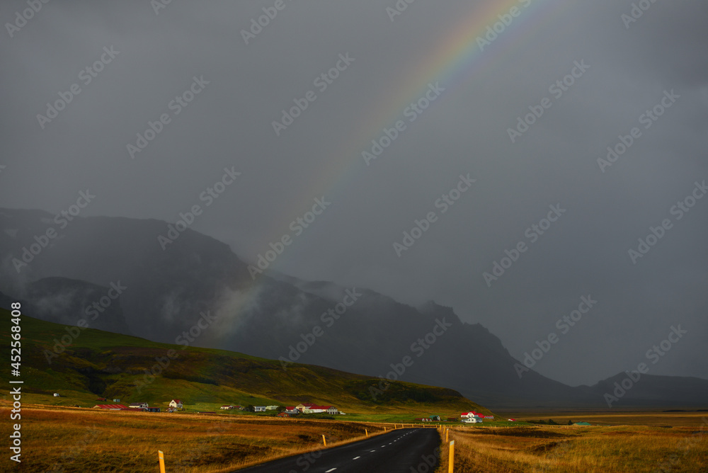 A rainbow above the rural hamlet of Hof at sunset, right by the Ring Road (Route One), on the south coast of Iceland