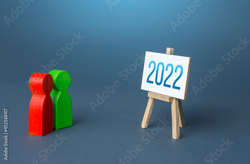 Red and green people look at easel 2022 year. Summing up, analytics and forecasting. Report presentation. Summarizing. Analysis of companys economic performance. Statistics. New plans for next year.