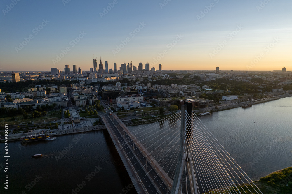 Fototapeta premium Widok na wieżowce w centrum Warszawy o zachodzie słońca, złota godzina, nad mostem świetokrzyskim