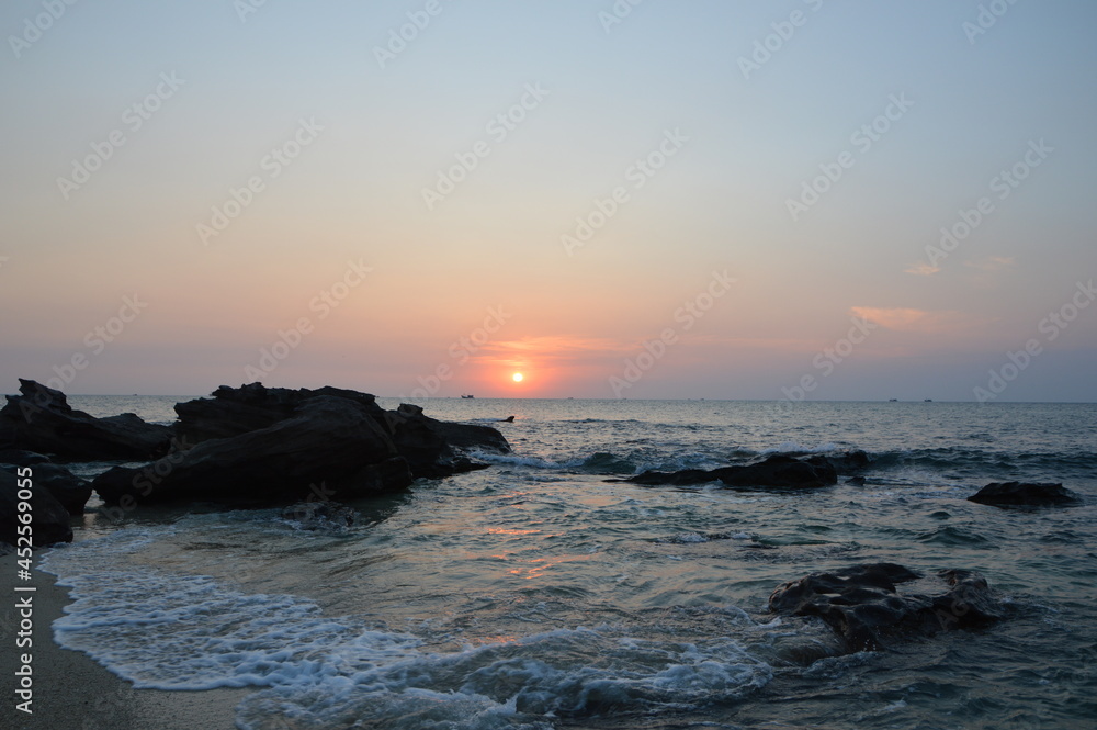 Waves washing up on shore of Rock Island in Phu Quoc, Vietnam during sunset hour