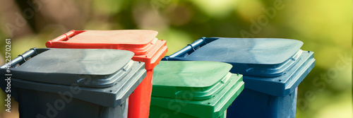 Εκτύπωση καμβά Many multicolored trash bin on green nature background