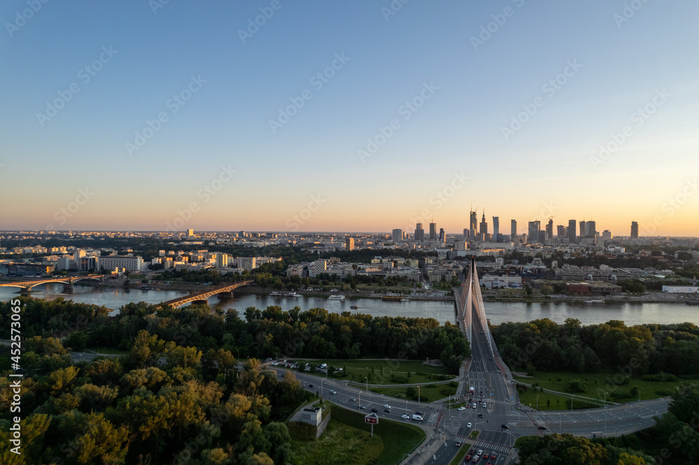 Widok na wieżowce w centrum Warszawy o zachodzie słońca, złota godzina, nad mostem świetokrzyskim - obrazy, fototapety, plakaty 